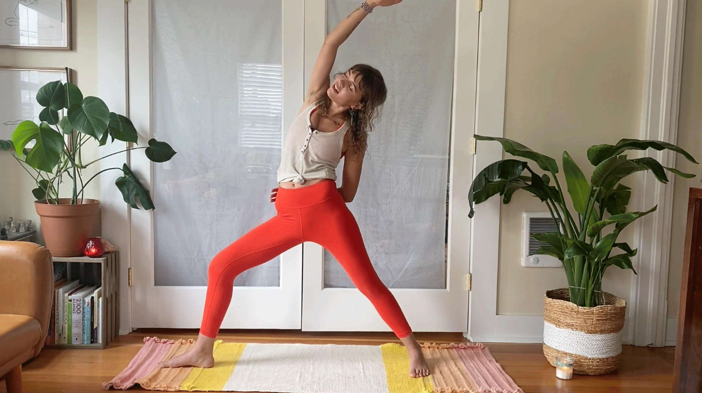Woman on her yoga mat leaning to the side in Reverse Warrior Pose in yoga