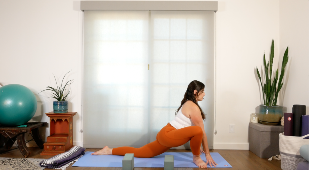 Woman in Low Lunge on a yoga mat with her front knee bent and her back knee down