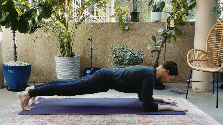 Man practicing Forearm Plank Pose on his yoga mat