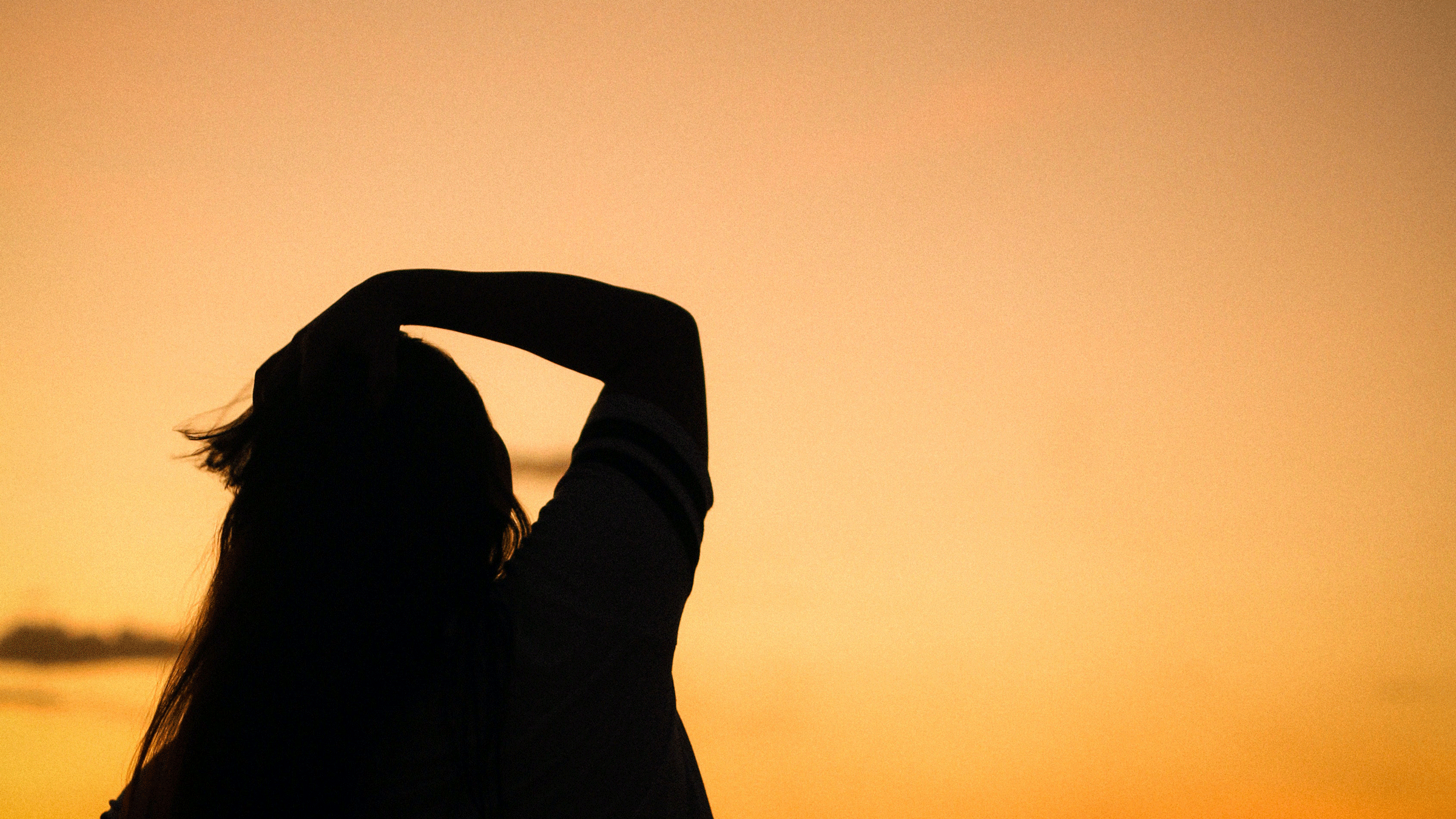 Woman standing outside at sunset looking into the distance