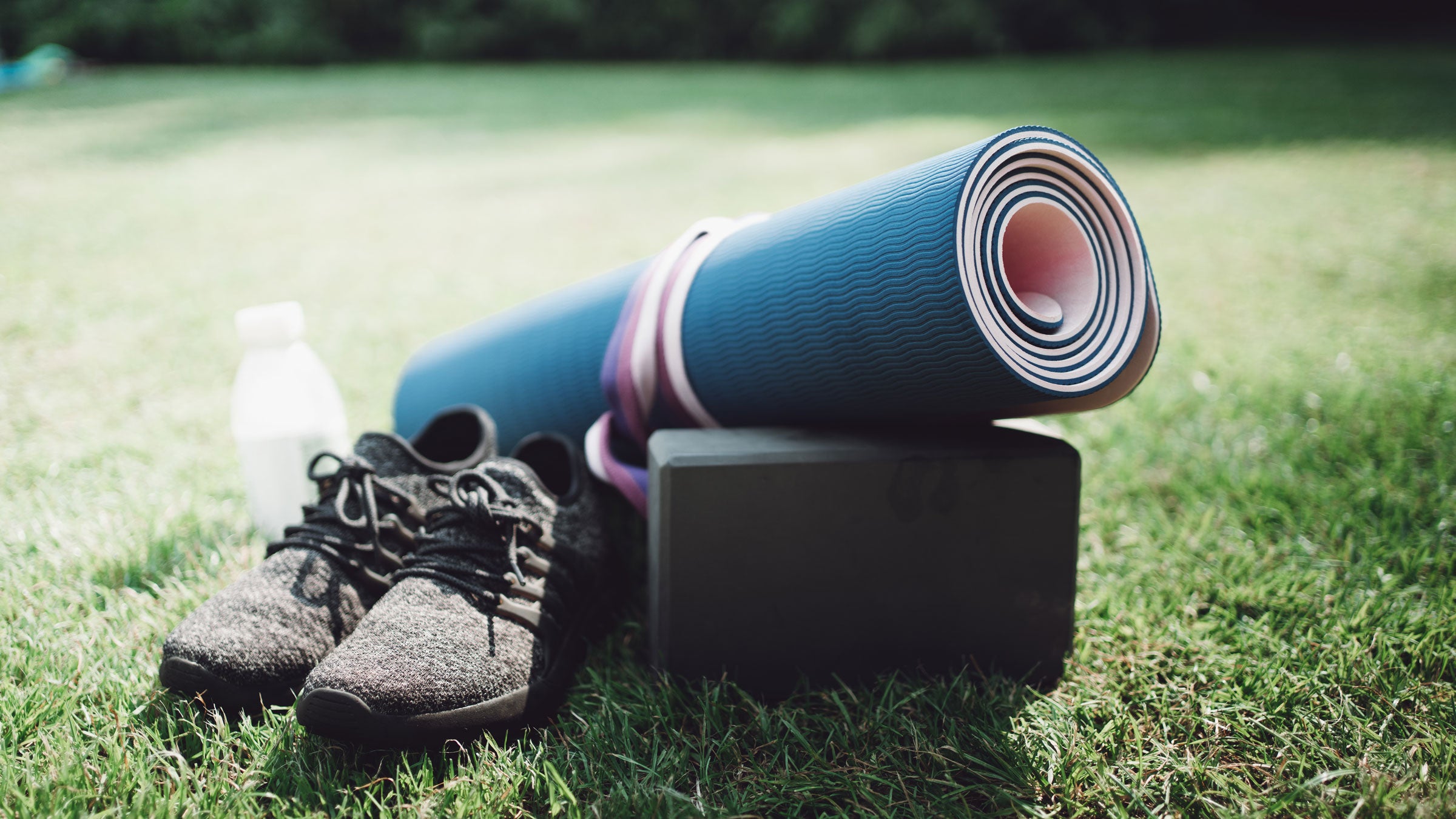 Cleats and a yoga mat pictured on a football field