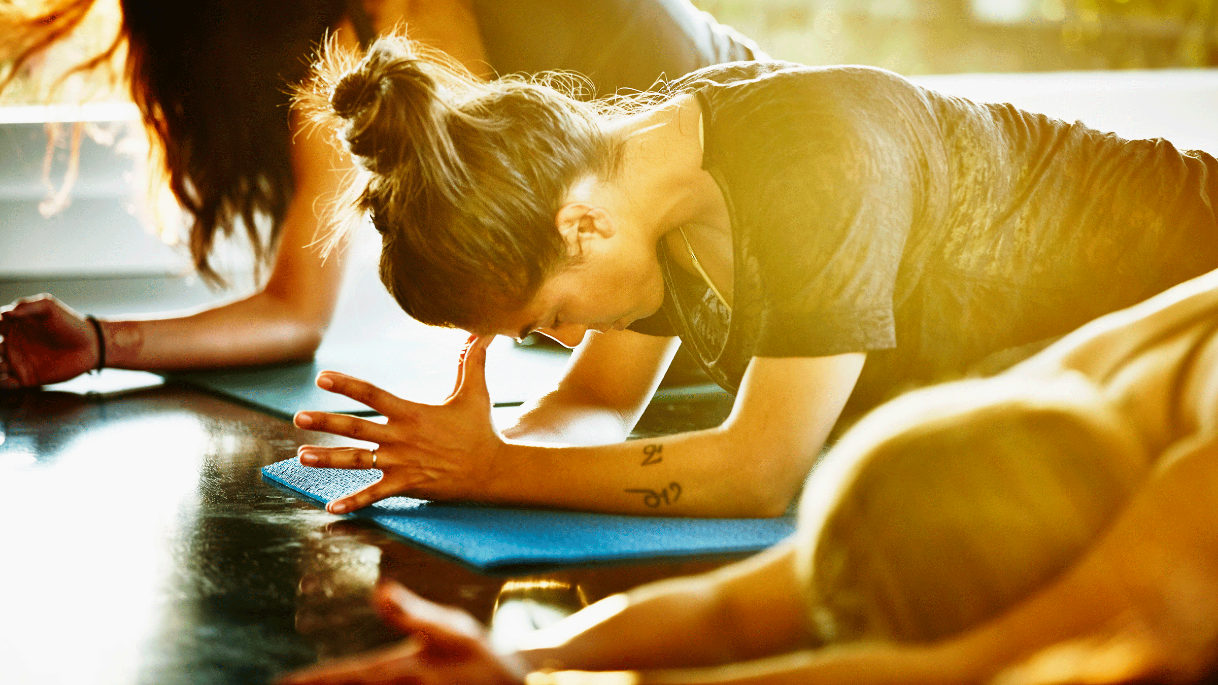 Woman on yoga mat in mild pain or discomfort and breathing through it