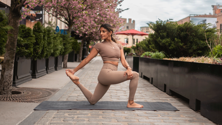 Woman kneeling on a yoga mat in a low lunge while twisting to the right with her left hand on her thigh