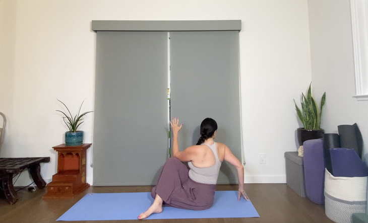 Woman in purple pants practices Ardha Matsyendrasana, Half Lord of the Fishes