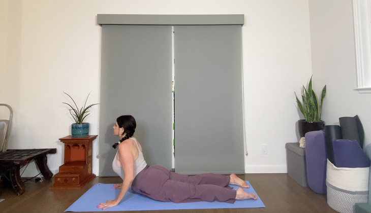 A woman practices a variation of Bhujangasana