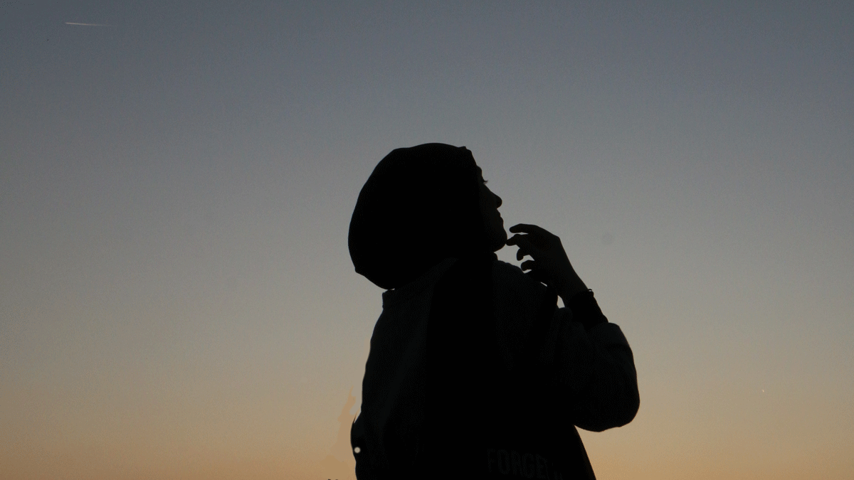 Woman standing outside at night contemplating the weekly astrology forecast, including the Sun in Taurus