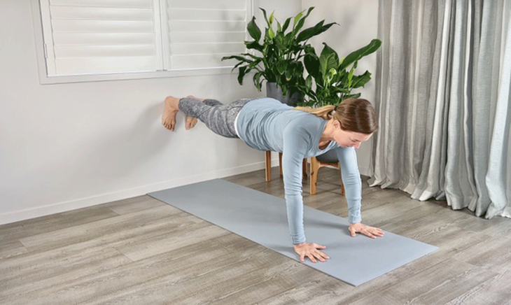 A woman is doing yoga, leaning her legs against the wall