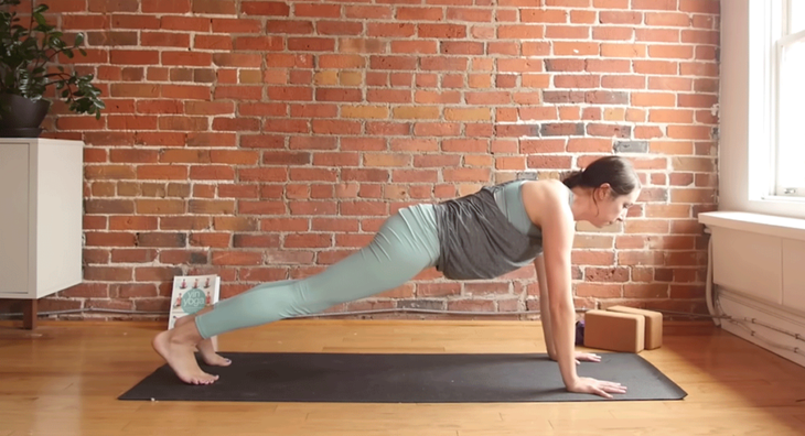 Cassandra Reinhardt practices plank pose during a 10-minute morning yoga class on YouTube