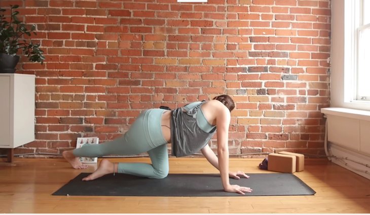 Cassandra Reinhardt practices a side stretch on a yoga mat