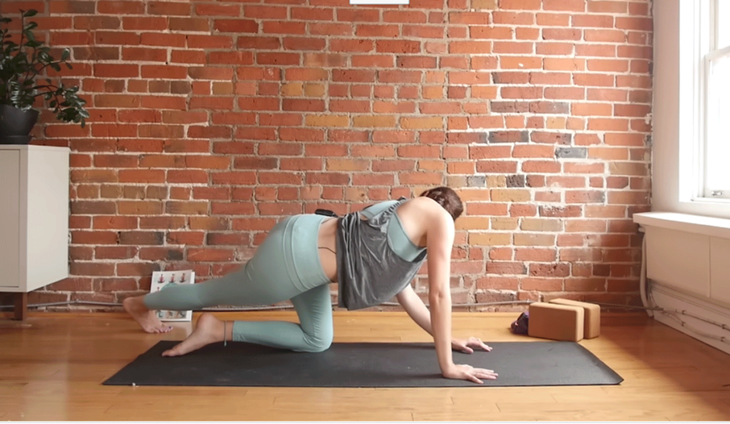 Kassandra Reinhardt practicing a side stretch on a yoga mat