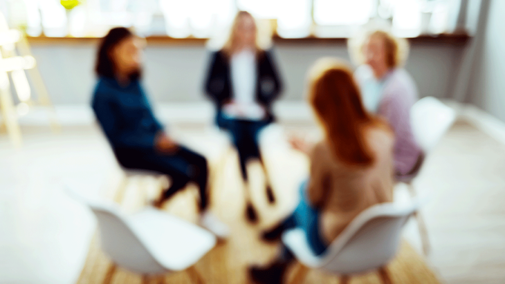 Women in therapy hold a group discussion