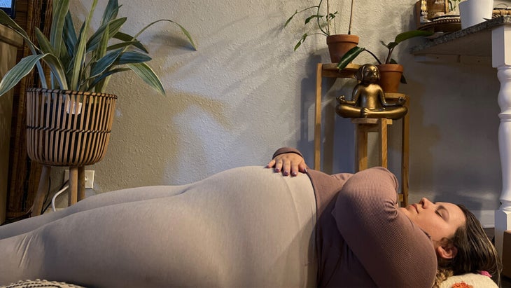 Woman lying on her back on her yoga mat in yin yoga