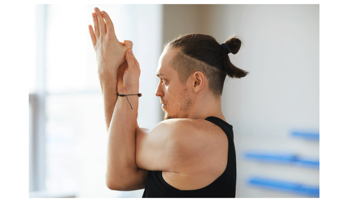 Man at the gym practicing Eagle arms