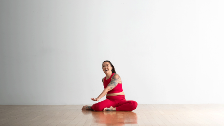 Woman sitting in a yoga pose and laughing
