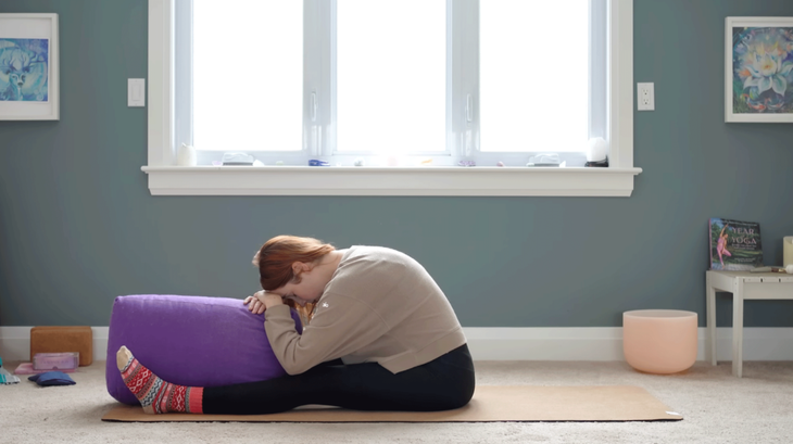 Yoga with Kassandra practicing a seated forward fold in a yin yoga practice