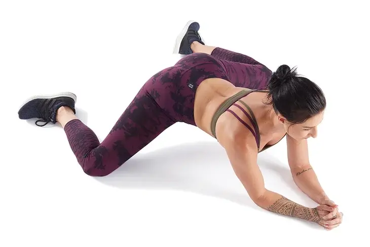 Woman athlete practicing one of the best hip stretches for athletes known as Frog Pose