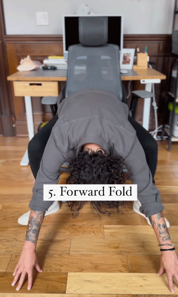 Man sitting in a chair leaning forward while practicing desk yoga