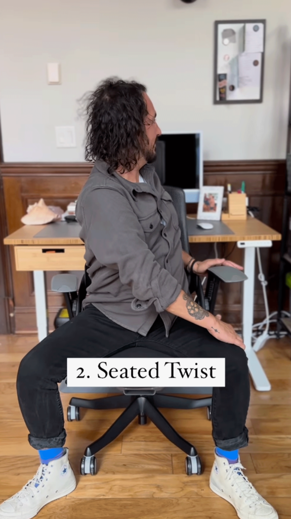 Homem sentado em uma cadeira em uma mesa virando-se para o lado para alongar os músculos oblíquos.
