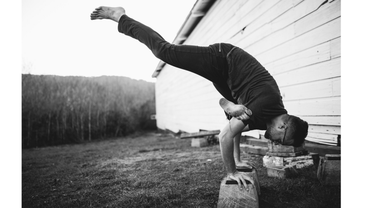 MC YOGI practicing an arm balancing yoga pose, Flying One-Legged Pigeon.