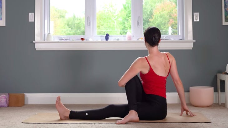 Woman practicing yoga for Sagittarius while twisting to the right in Half Lord of the Fishes