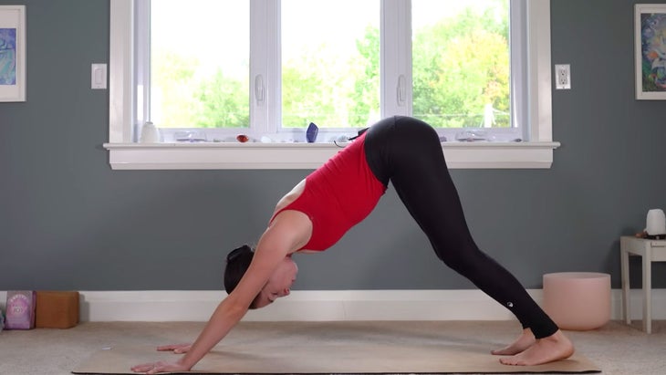 Woman practicing Downward-Facing Dog on a yoga mat