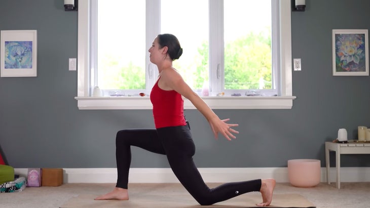 Woman in a Low Lunge with her back knee down and her arms sweeping back alongside her hips