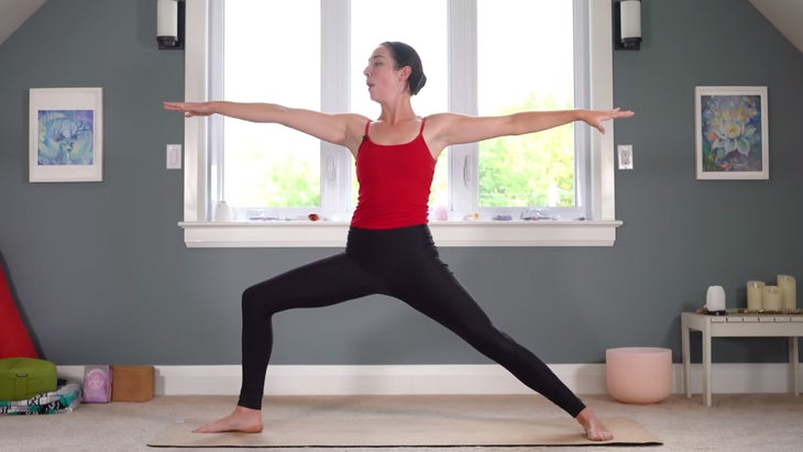 Woman in Warrior 2 Pose during a yoga for Sagittarius practice