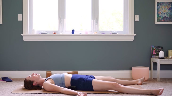 female yoga instructor in savasana pose