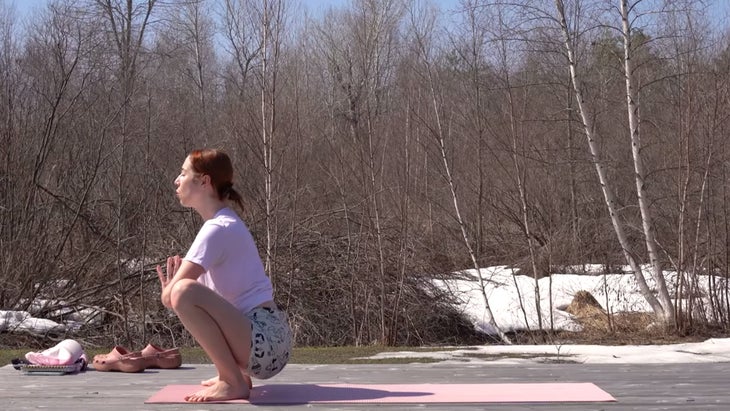 yoga instructor in squat pose