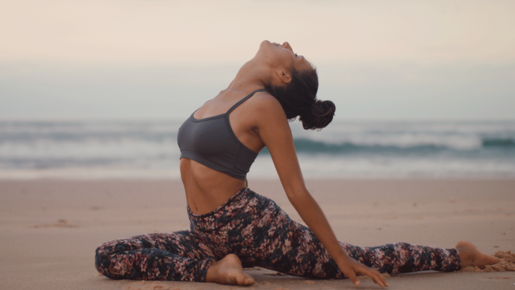 Woman practicing a variation of Eka Pada Rajakapotasana in ashtanga yoga