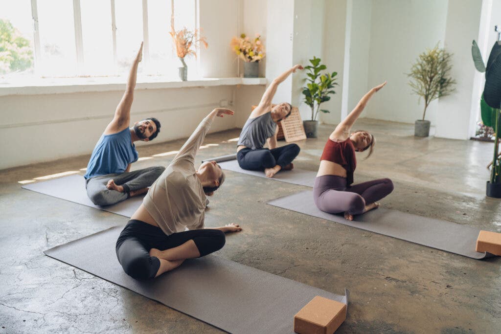 Students performing side bends in yoga class.