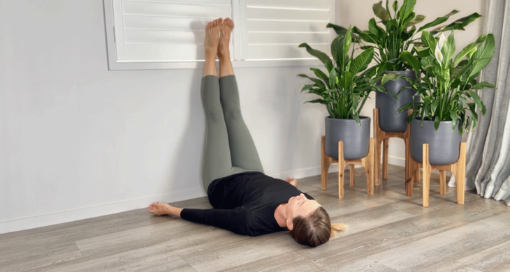 A yoga teacher practicing legs up the wall as a ski stretch apres a ski session.