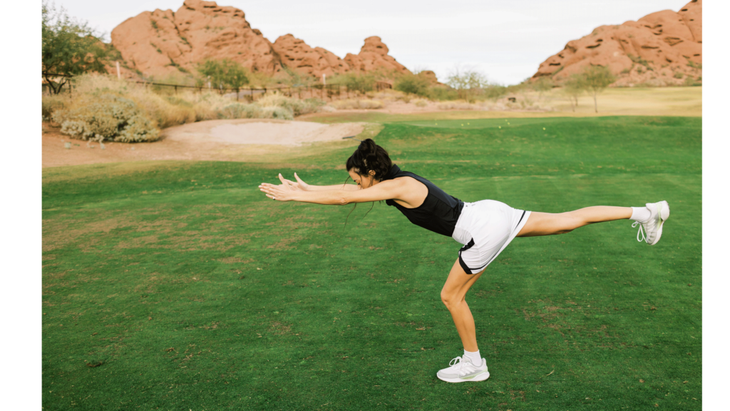 Woman practicing Warrior 3 on a golf course to enhance core stabilizing muscles along the spine.