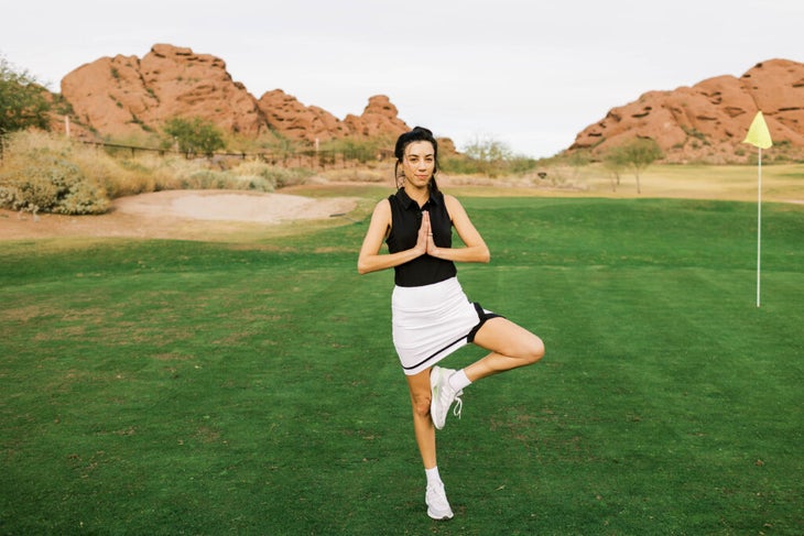 Woman standing in the yoga pose known as Tree while doing exercises for golfers to build stability and balance.