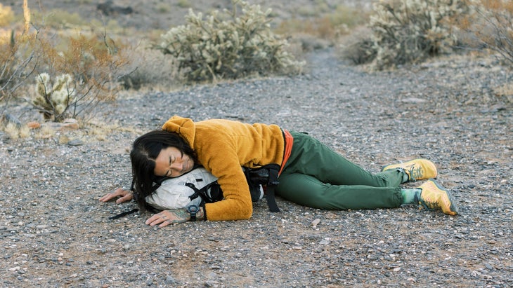 hiker performing a restful yoga pose with their backpack in the Arizona desert