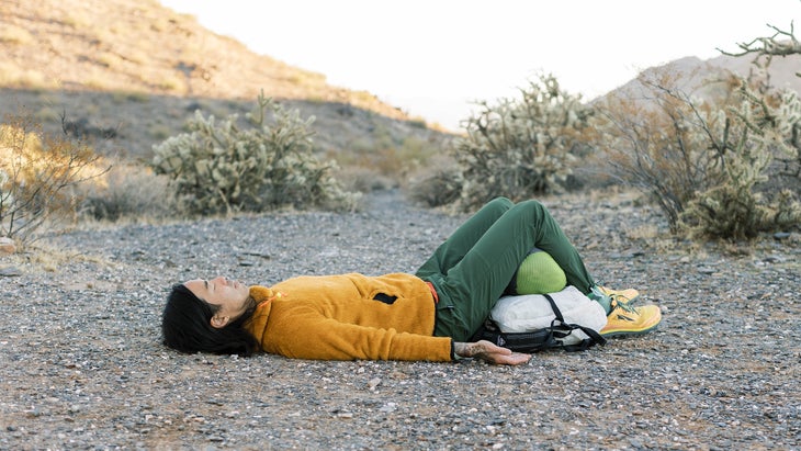 Backpacker practicing yoga near his tent along a desert trail in Arizona