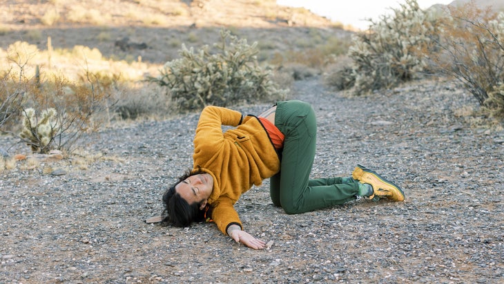 backpacker engaged in yoga poses near their camping spot on a desert trail in Arizona