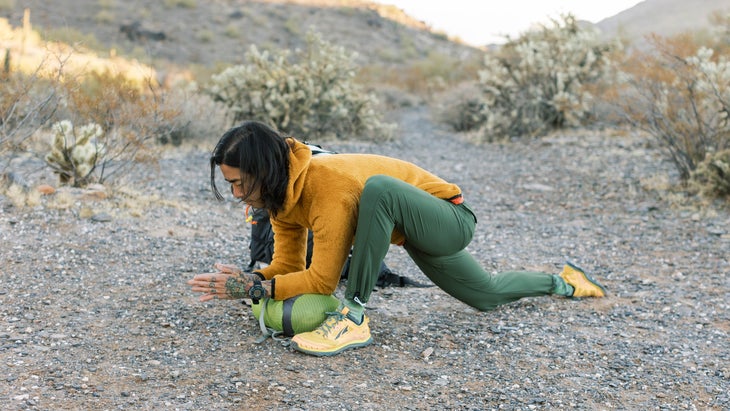 backpacker in the Arizona desert doing yoga poses near their tent