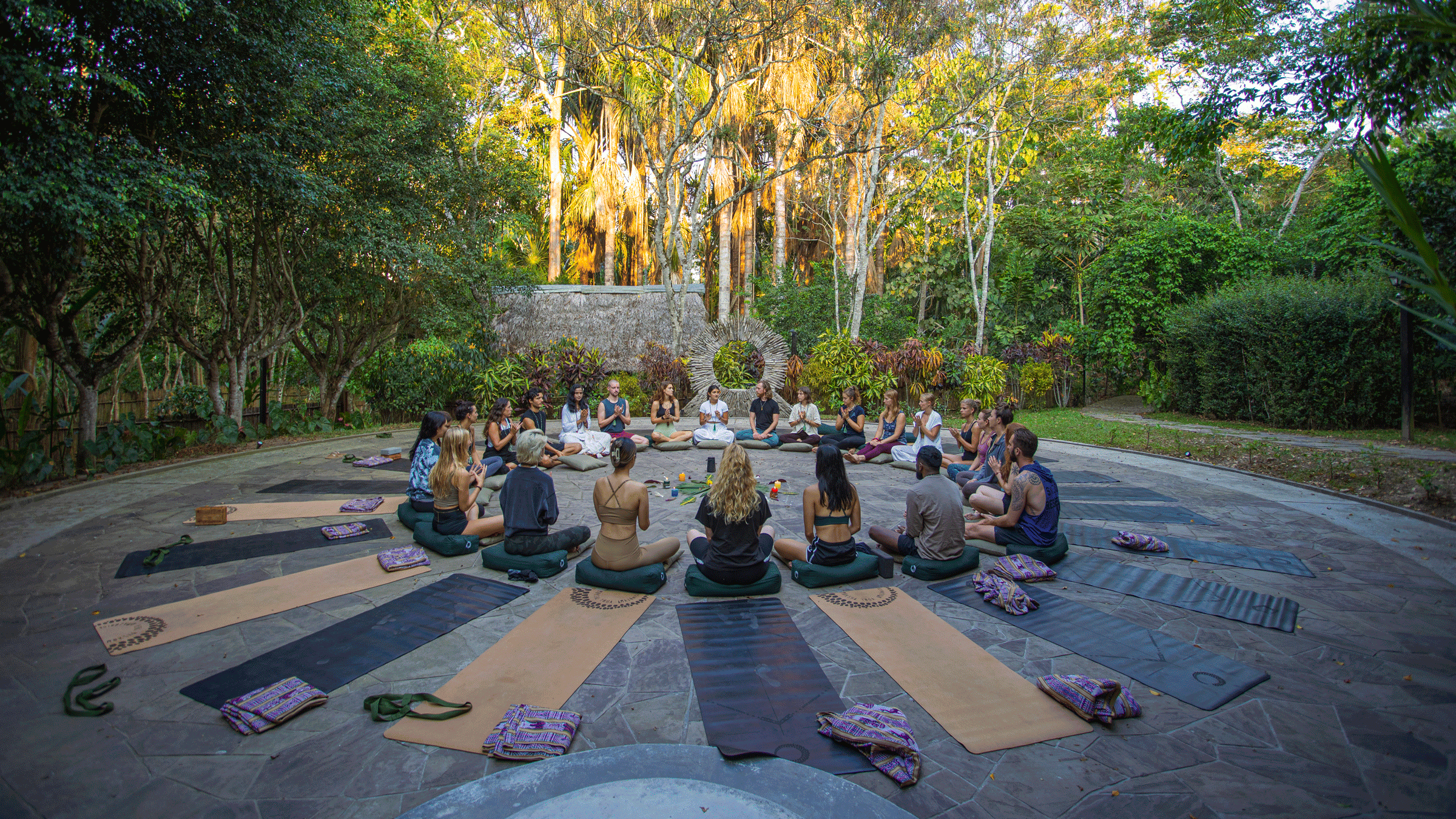People sitting in a circle participating in a yoga class in nature.