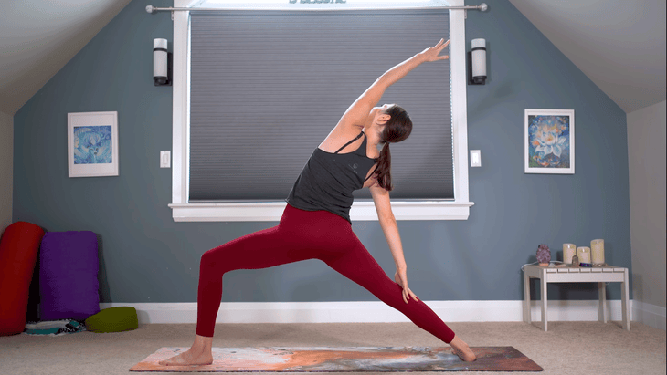 Woman practicing Reverse Warrior Pose on a yoga mat