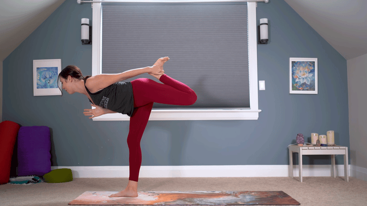 Woman practicing Warrior 3 with her hand reaching for her lifted ankle