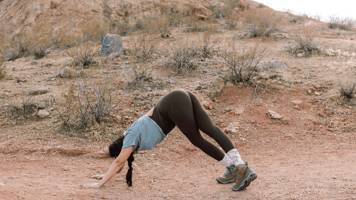 Woman stretching her calves while hiking