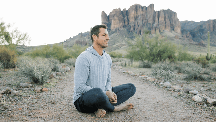 Man sitting on a hiking trail taking a break