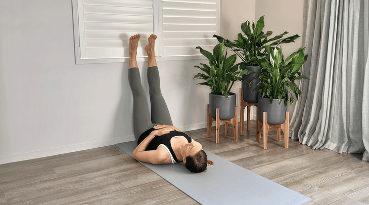 Woman lying on a yoga mat with her legs up the wall to release her psoas muscle