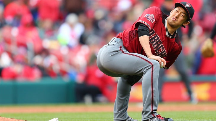 Yoshihisa Hirano of the Arizona Diamondbacks practices a yoga squat on a baseball field