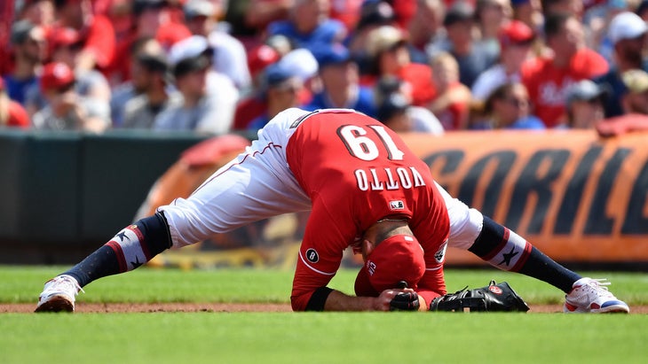 Joey Vatto of the Cincinnati Reds practices a forward standing straddle on a baseball field