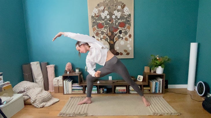 woman practicing a yoga pose on a mat bending to the side