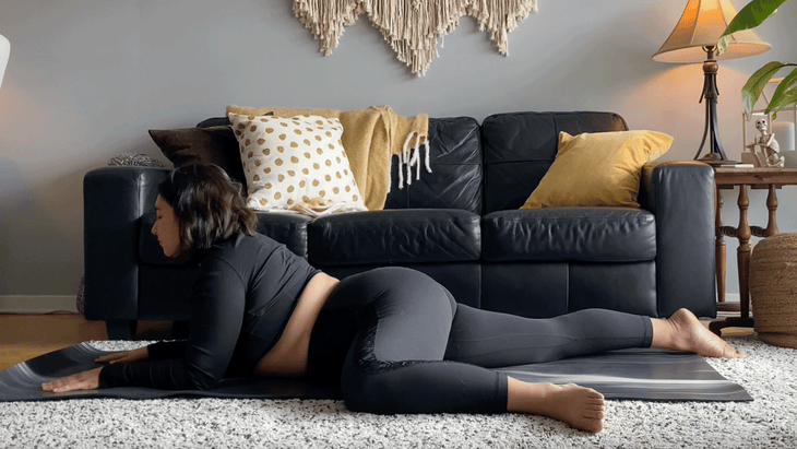 Yoga teacher on a mat practicing a hip opener