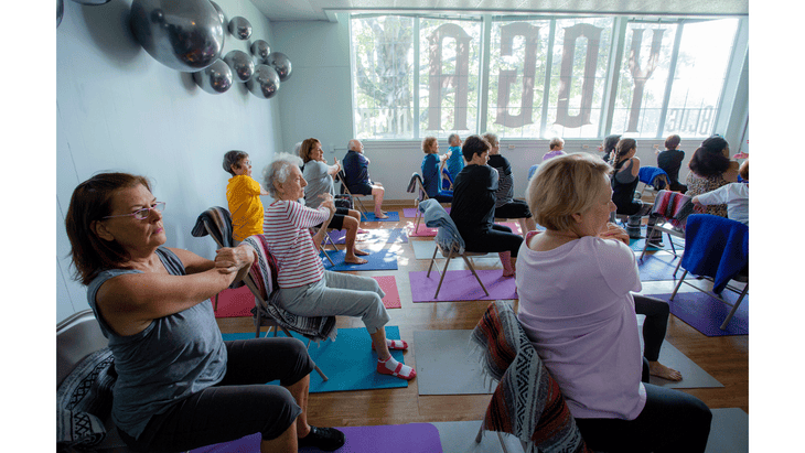 A yoga for seniors class of students sitting in chairs and stretching at Blue Yoga Nyla with teacher Stacey Reynolds