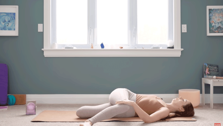 Woman on a yoga mat practicing Cat Pulling Its Tail, a yin yoga for chakras pose